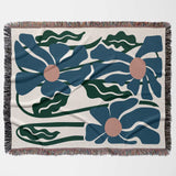 Floral patterned Matisse style blue flowers cotton woven throw blanket with blue flowers and green leaves on a beige background
