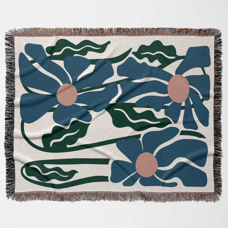 Floral patterned Matisse style blue flowers cotton woven throw blanket with blue flowers and green leaves on a beige background
