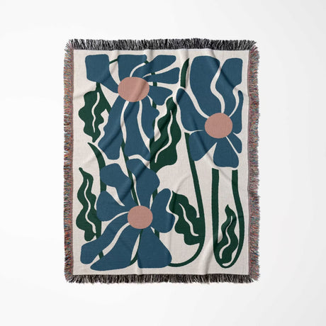 Floral patterned Matisse style blue flowers cotton woven throw blanket with blue flowers and green leaves on a white background