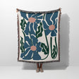 Floral patterned Matisse style blue flowers cotton woven throw blanket with blue flowers on a white background