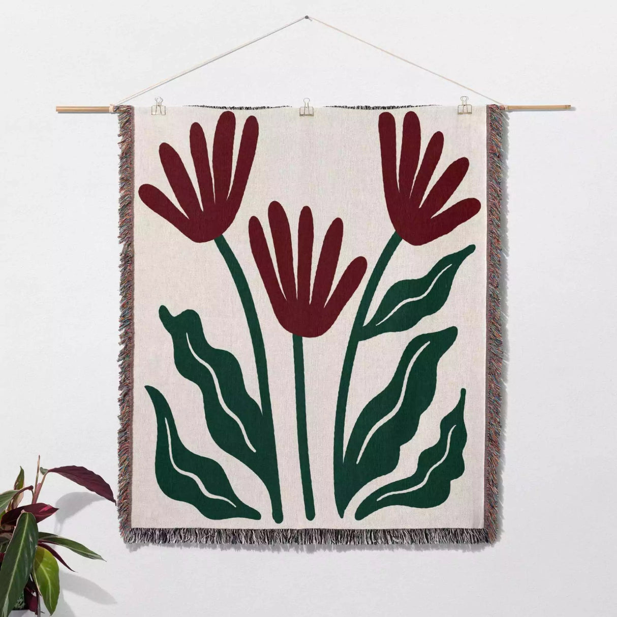 Matisse style red flowers woven throw blanket as woven wall art with red flowers and green leaves on a white background