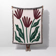 Floral patterned Matisse style red flowers woven throw blanket with red flowers and green leaves on a white background