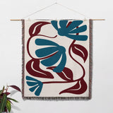 Matisse style red and blue cotton woven throw blanket as a woven tapestry with blue and red abstract design on a white wall