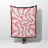 Lighter red abstract Matisse throw blanket held over a person on a white background