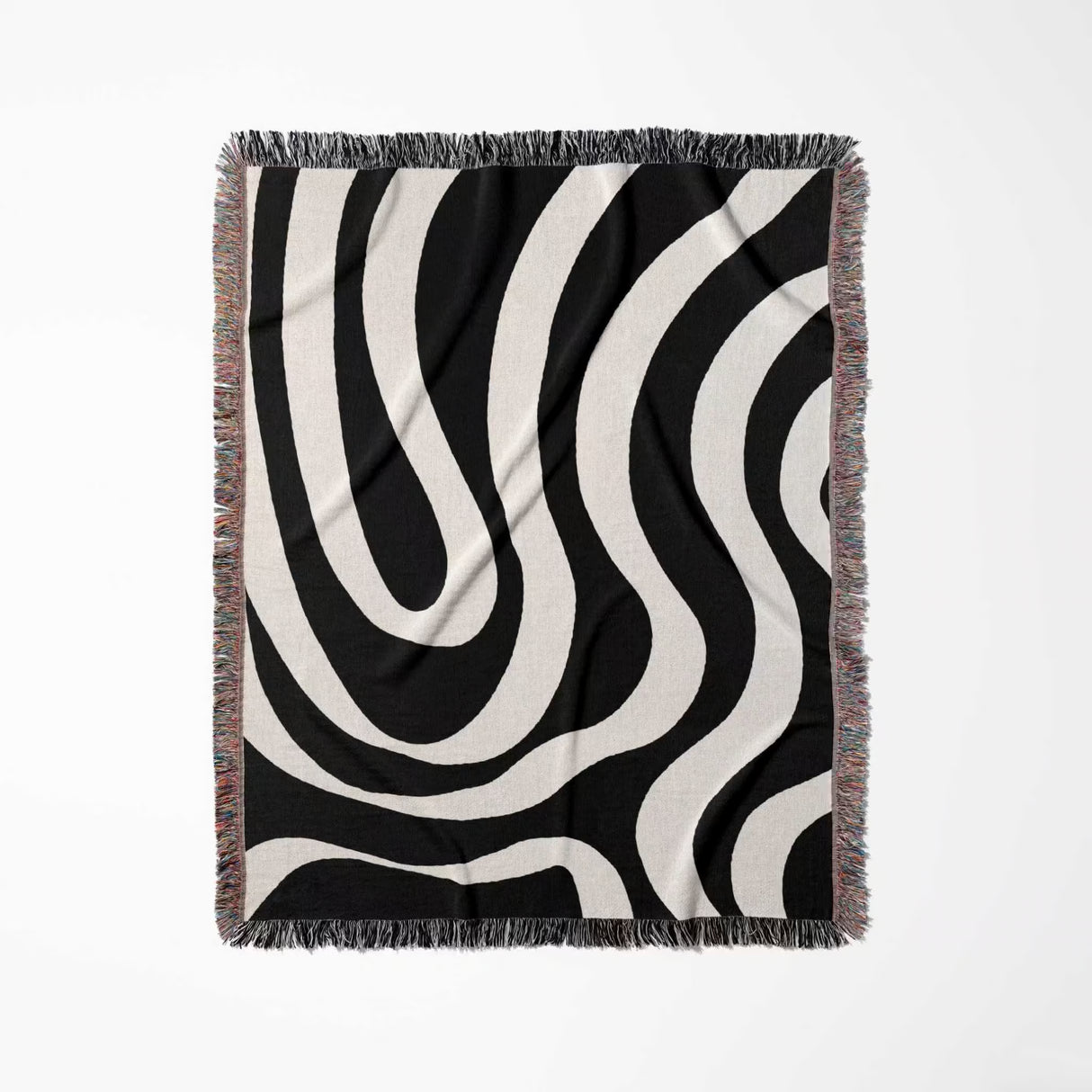 Black and white modern abstract woven blanket throw tapestry with fringe full view on a light gray background