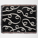 Black and white modern accent woven blanket throw tapestry flat lay on a white background.