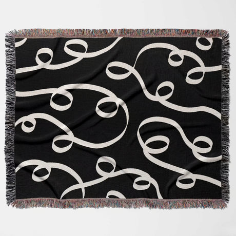 Black and white modern accent woven blanket throw tapestry flat lay on a white background.