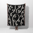 Black and white modern accent woven blanket throw tapestry held by a person on a white background