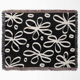 Black and white modern artsy flowers woven blanket throw flat lay on a white background.