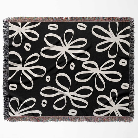Black and white modern artsy flowers woven blanket throw flat lay on a white background.