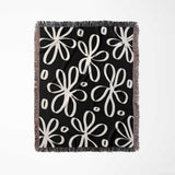 Black and white modern artsy flowers woven blanket throw full view on a white background.