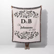 Monogrammed cotton throw blanket perfect engagement and wedding gift held by a person on a white background