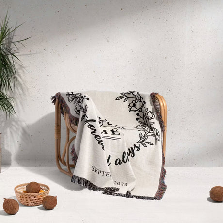Mr and Mrs cotton wedding anniversary gift woven blanket with floral design and text draped over a chair against a light background