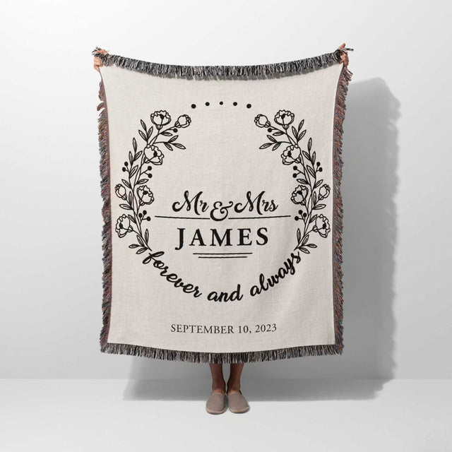 Mr and Mrs cotton wedding anniversary gift woven blanket with floral design and text held by a person on a white background