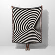 Black and white optical illusion hole woven blanket throw tapestry held by a person on a white background.