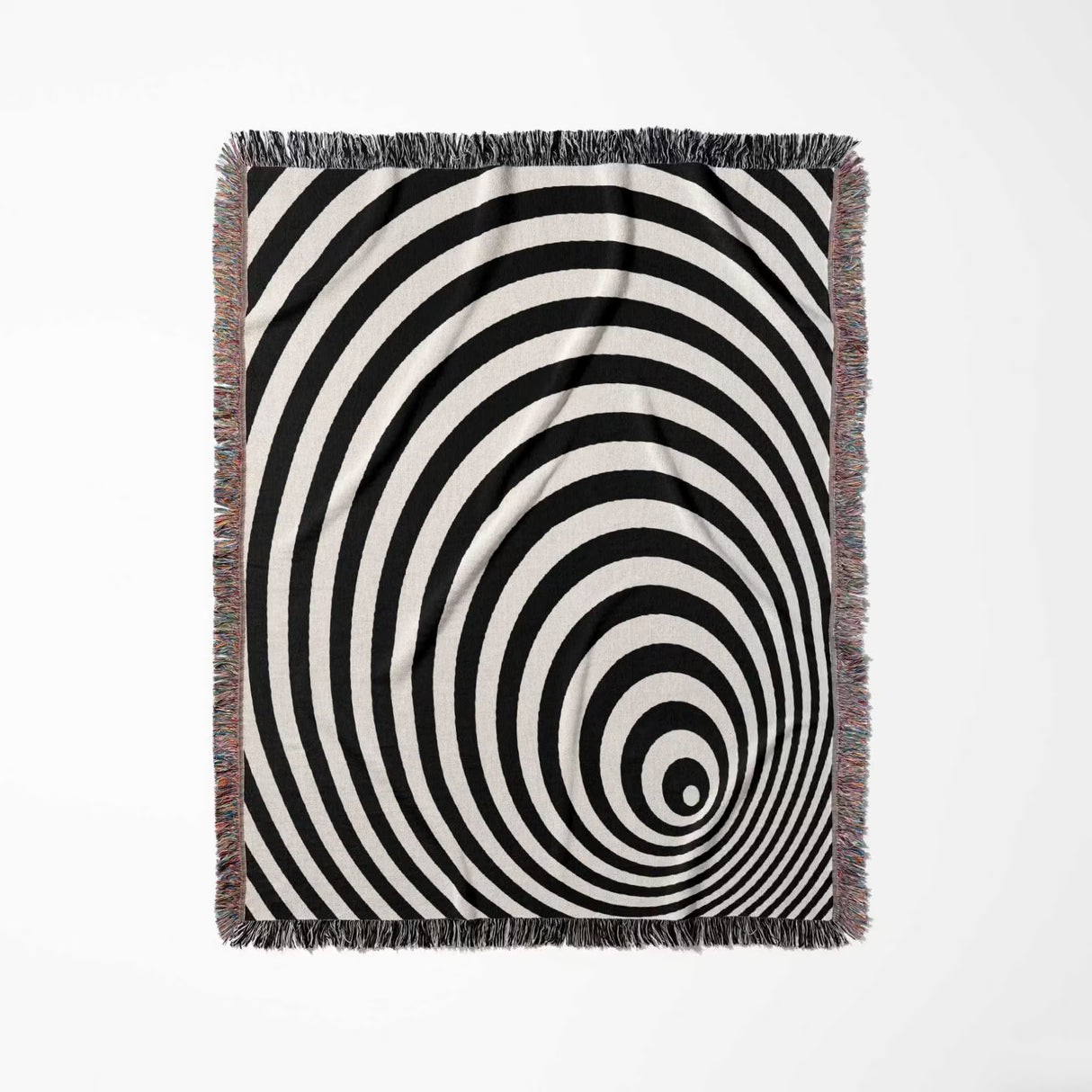 Black and white optical illusion wormhole woven blanket throw tapestry with fringes full view on a light gray background.