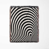 Black and white optical illusion wormhole woven blanket throw tapestry with fringes full view on a light gray background.