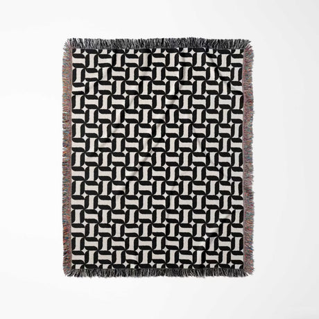 Black and white patterned geometric woven blanket throw tapestry with geometric design full view on a white background.
