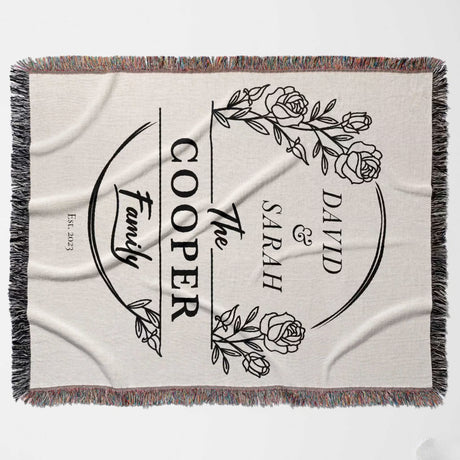 Personalized 2 year anniversary gift for wife woven throw blanket with 'The Cooper Family' design featuring names and roses flat lay on a light background