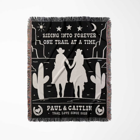 Personalized cowboy and cowgirl 2nd anniversary gift woven throw blanket full view with desert landscape design, silhouettes of a couple, and text on a black background.