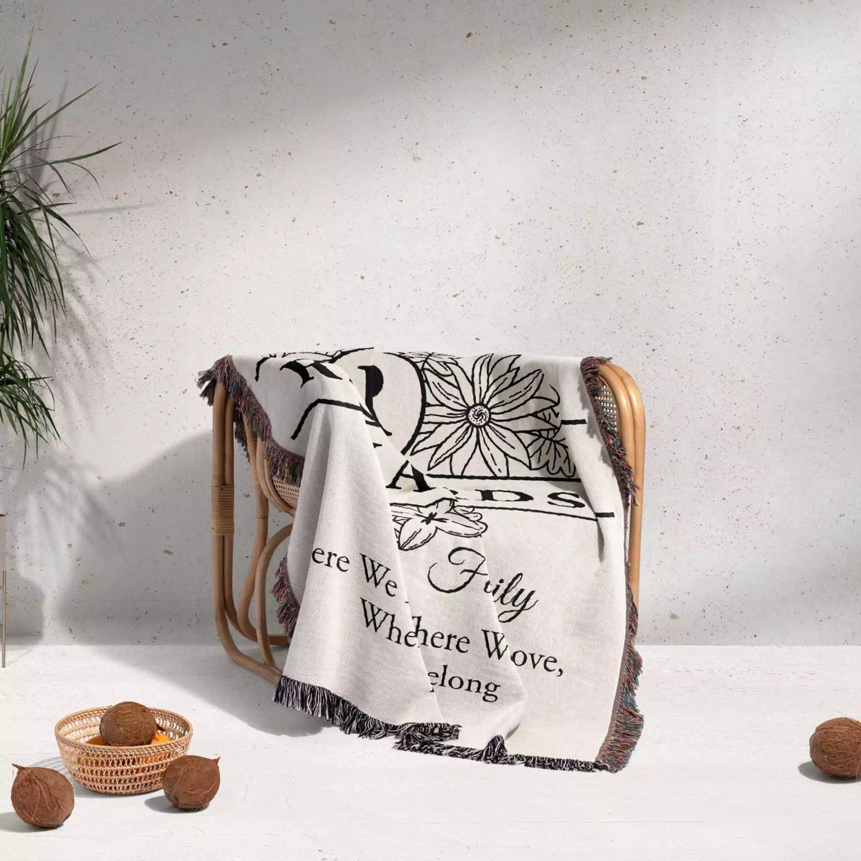 Personalized family name blanket - new home unique housewarming gift with floral and text design draped over a chair on a light background