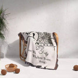 Personalized family name blanket - new home unique housewarming gift with floral and text design draped over a chair on a light background