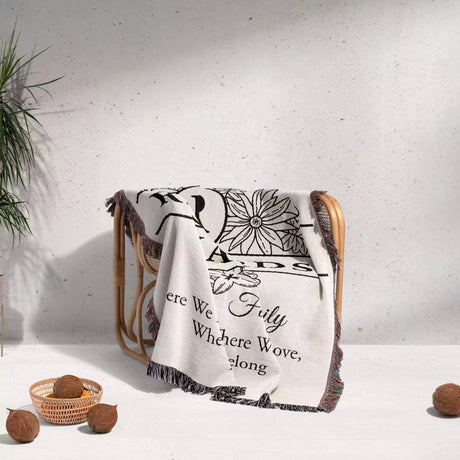 Personalized family name blanket - new home unique housewarming gift with floral and text design draped over a chair on a light background