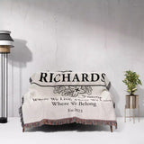 Personalized family name blanket - new home unique housewarming gift with 'Richards Family' text draped over a couch against a white wall.