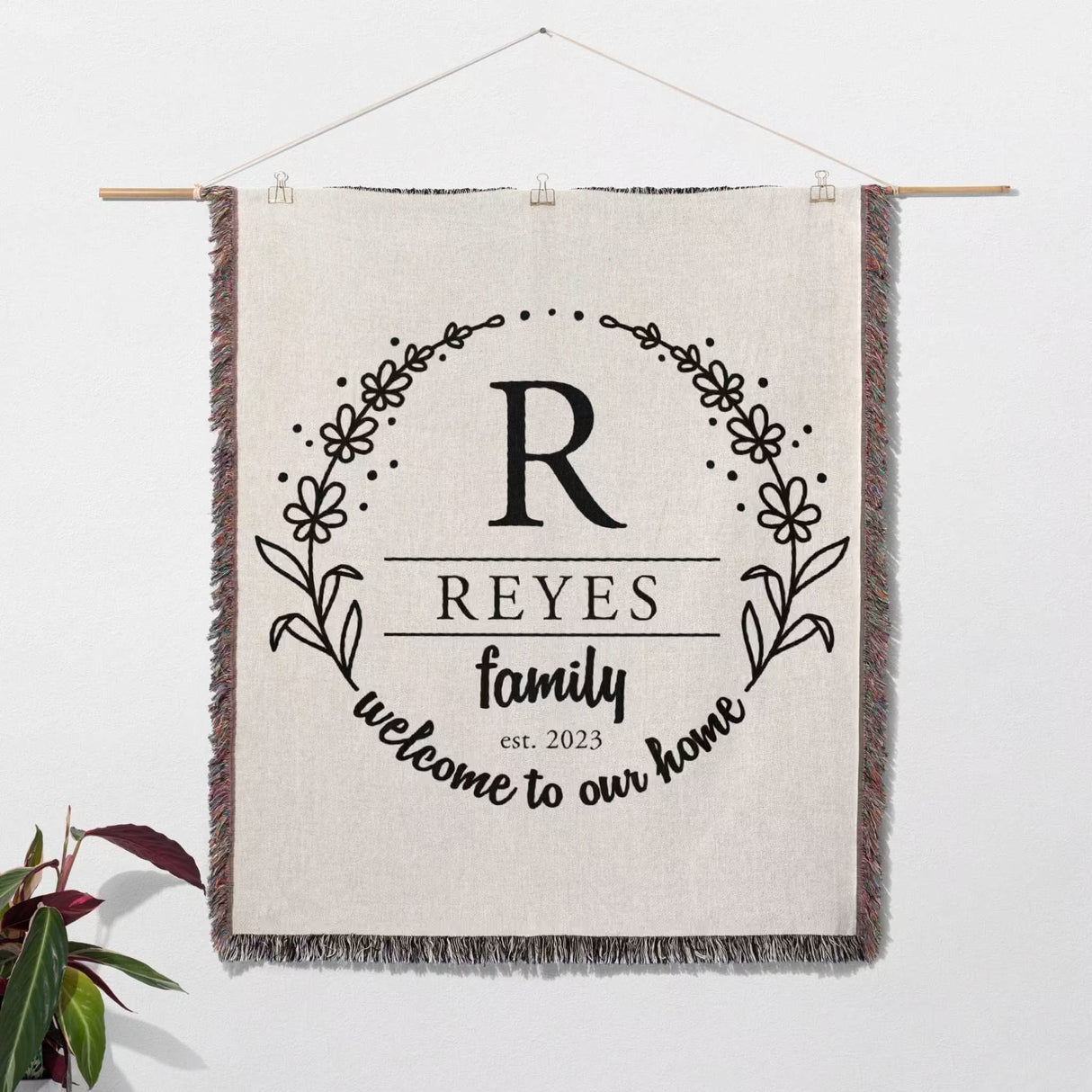 Personalized family name woven blanket rustic home décor gift wall hanging with 'REYES family welcome to our home' text on a white background