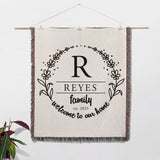 Personalized family name woven blanket rustic home décor gift wall hanging with 'REYES family welcome to our home' text on a white background