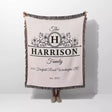 Personalized family name and address blanket with 'Harrison Family' design held by a person on a white background