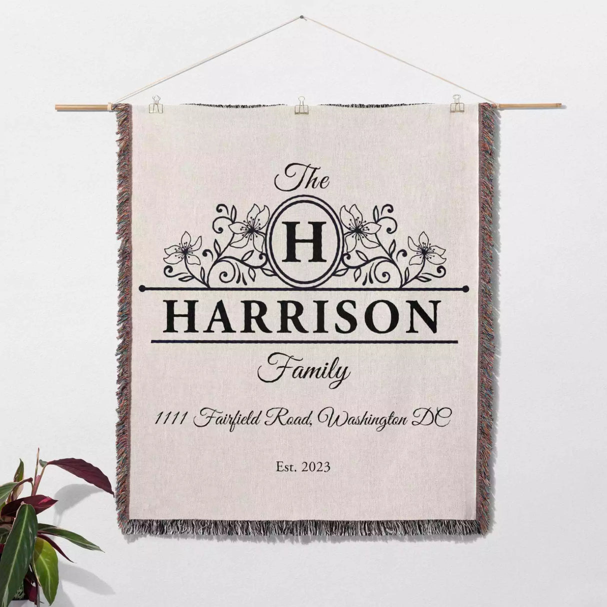 Personalized family name and address blanket with decorative text and design on a white background wall