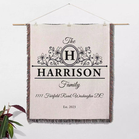 Personalized family name and address blanket with decorative text and design on a white background wall