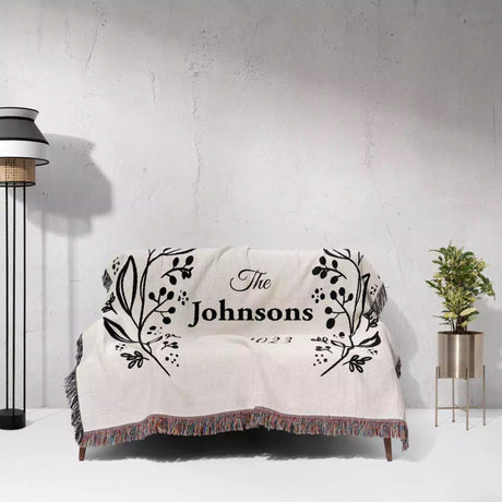 Personalized gift for couple unique cotton anniversary gift woven blanket  on a couch against a light gray wall.