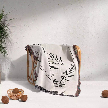 Personalized Mr and Mrs blanket with decorative text and patterns draped over a chair on a light background
