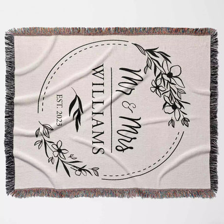 Personalized blanket with 'Mr & Mrs' and 'Williams' text, floral design, and year flat lay on a light background