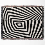 Psychedelic abstract art woven blanket throw tapestry with fringe flat lay on a white background.