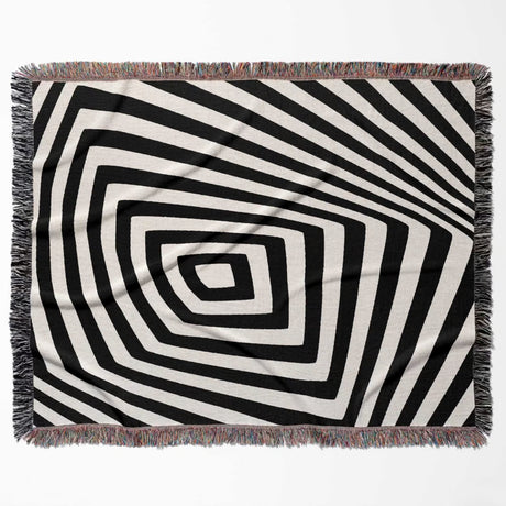 Psychedelic abstract art woven blanket throw tapestry with fringe flat lay on a white background.
