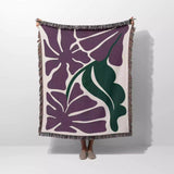 Decorative purple Matisse flowers woven throw blanket with purple and green floral pattern on a white background