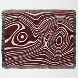 Red abstract woven throw blanket with wavy pattern on a plain background