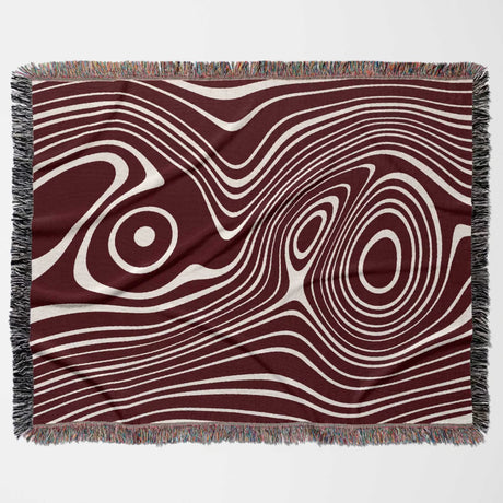 Red abstract woven throw blanket with wavy pattern on a plain background