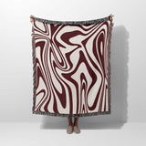 Red marble woven throw blanket for couch with abstract pattern hold by person on a white background