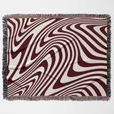 Red modern decorative woven throw blanket with wavy brown and beige pattern on a white background