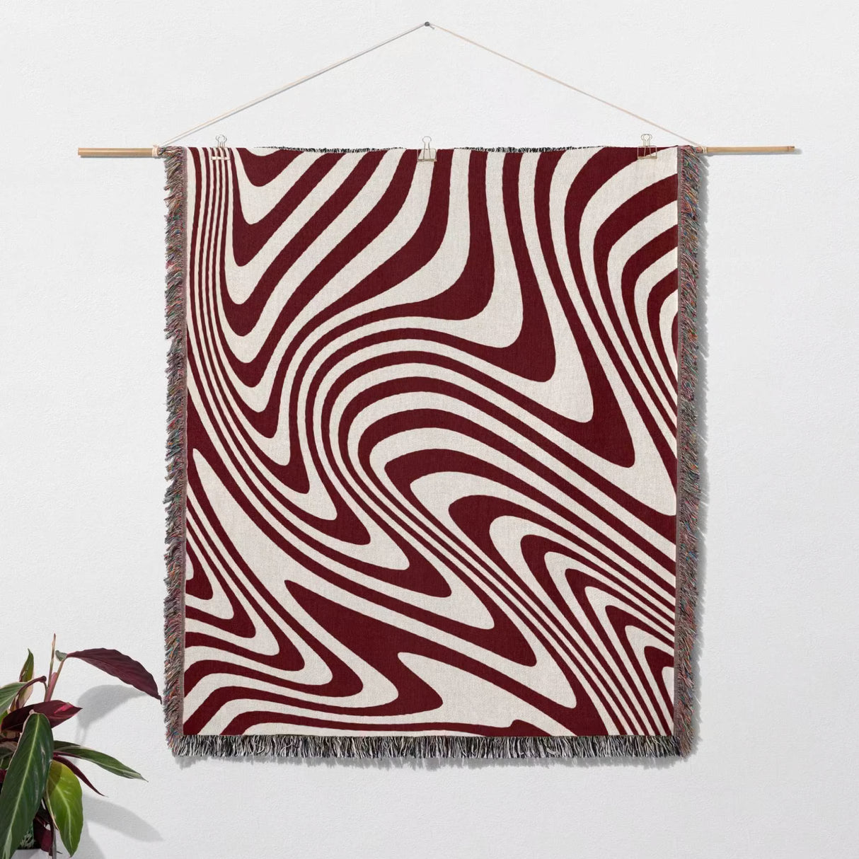 Red modern decorative woven throw blanket as wall hanging tapestry on a wall