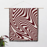 Red modern decorative woven throw blanket as wall hanging tapestry on a wall