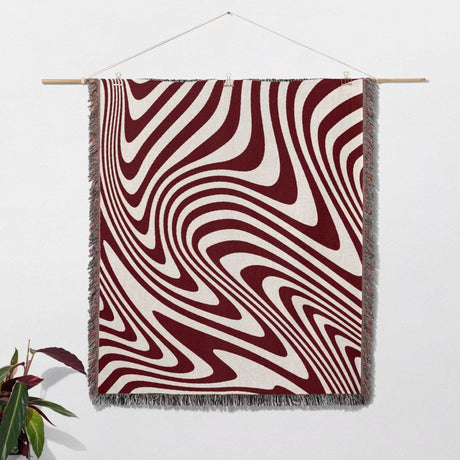 Red modern decorative woven throw blanket as wall hanging tapestry on a wall