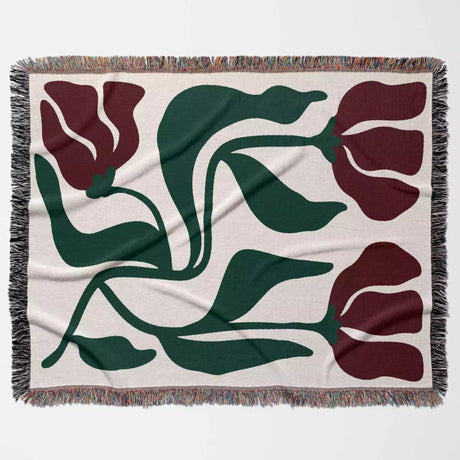 Red and green Matisse flower woven throw blanket floral patterned blanket with red flowers and green leaves on a beige background