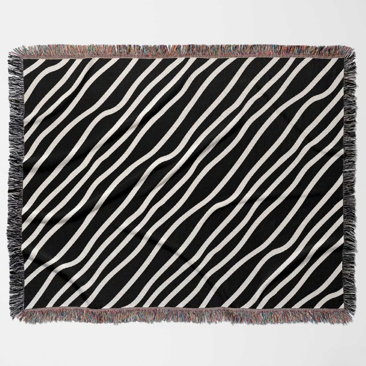Black and white retro abstract art woven blanket throw tapestry with fringed edges flat lay on a light gray background