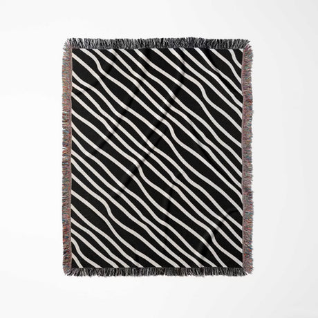 Black and white retro abstract art woven blanket throw tapestry full view with fringed edges on a light gray background