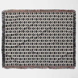 Black and white retro arrow lines woven blanket throw tapestry with fringed edges flat lay on a light gray background